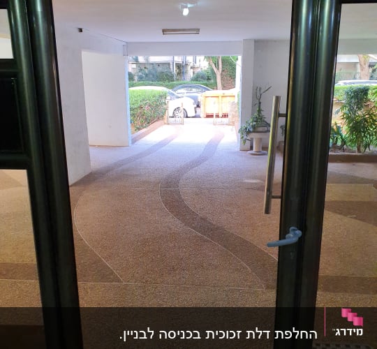 דלת זכוכית עם ידית מתכת בכניסה לבניין